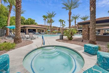 A pool area with a hot tub surrounded by palm trees. at The Laurel Apartments, Arizona, 85286